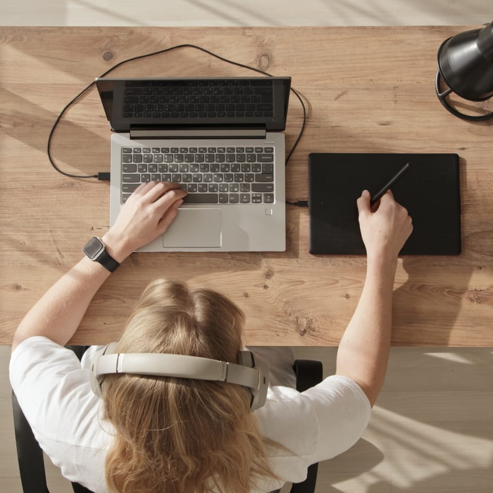 Overhead view of woman using laptop and tablet