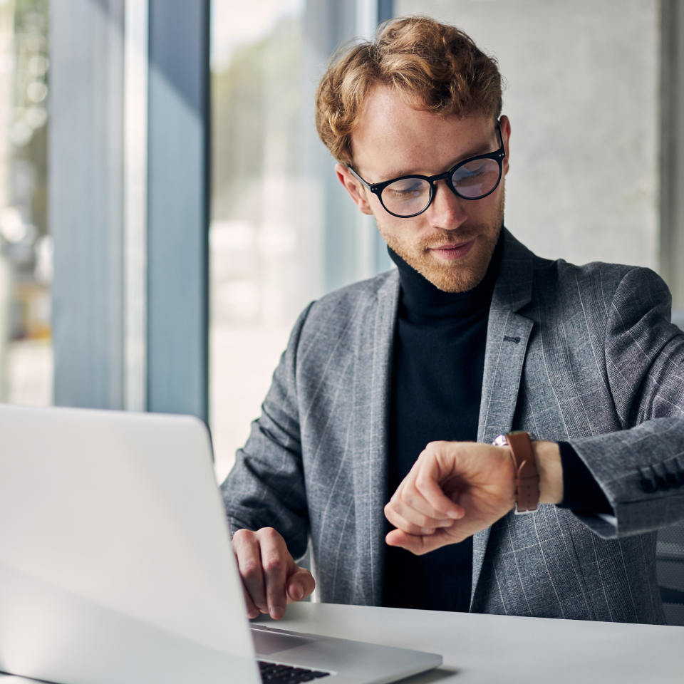 Man checking wrist watch in office