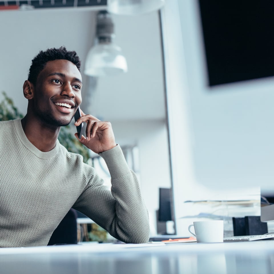 Young employee making phone call in office