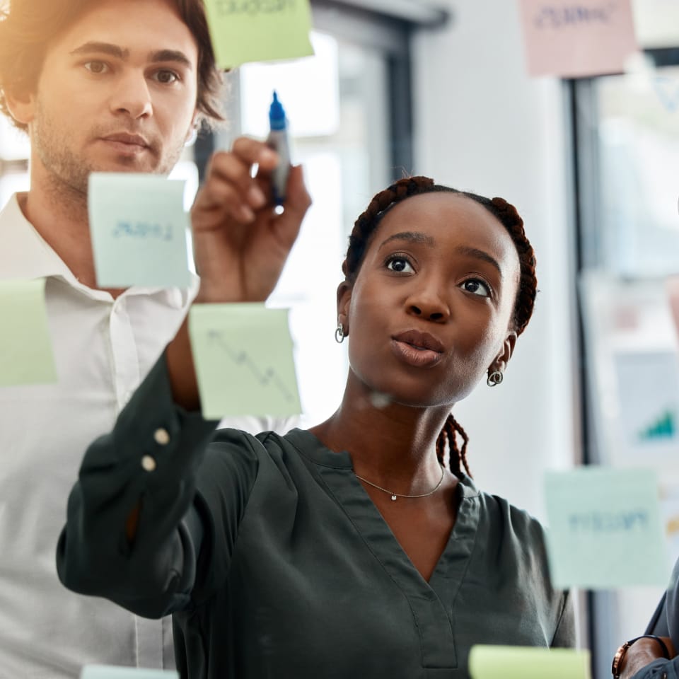 Woman discussing sticky notes with team