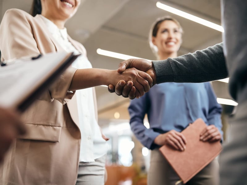 Group of coworkers shaking hands in office