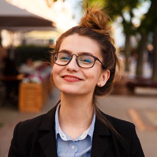 Young female business outfit wearing glasses and top knot