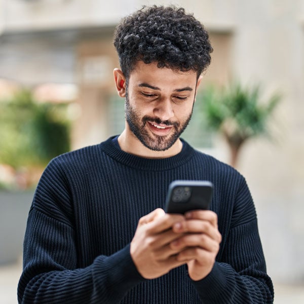 Young male looking at mobile phone device